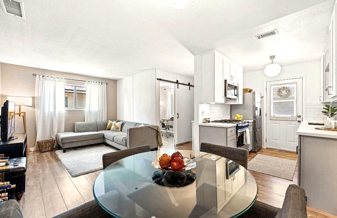 Open living and dining room with glass table and sectional sofa