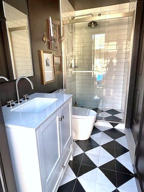 Bathroom with white vanity, freestanding tub and black and white checkered floor