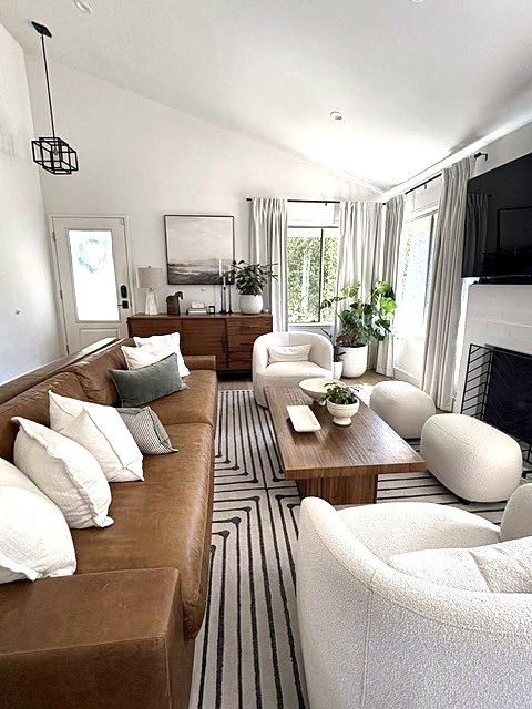 Living room with leather sofa, white pillows and a striped rug