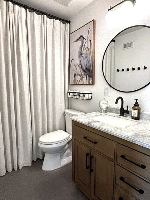 Bathroom with linen shower curtain, heron art and round mirror