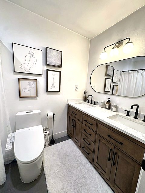 Bathroom with wood vanity, line-art prints and arched mirror