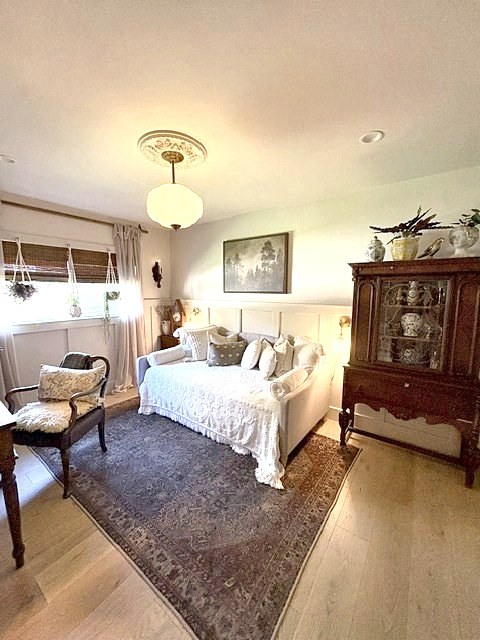 Collected sitting room with vintage rug, antique cabinet and warm pendant light
